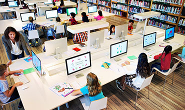 people sitting and working on computers in a library